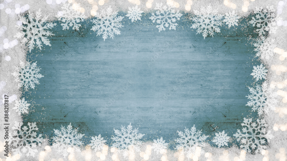 Fototapeta premium Winter / Advent / Christmas / holiday Background template - Frame made of snow with snowflakes, ice crystals and sparkles bokeh lights on blue turquoise wooden texture, top view with space for text