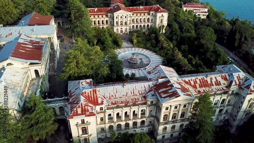 Aerial bird view footage of abandoned old mansion showing the building itself and the large abandoned fountain