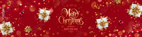 Gold Merry Christmas and New Year text on red holiday background with gift boxes, fir branches, ribbons, decoration, sparkles, confetti, bokeh, light. Xmas card. Vector Illustration, realistic vector