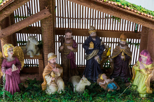 Crèche de Noël avec Joseph, Marie et le bébé Christ ainsi que les apôtre et animaux dans une vielle bergerie sur fond blanc neige avec décorations