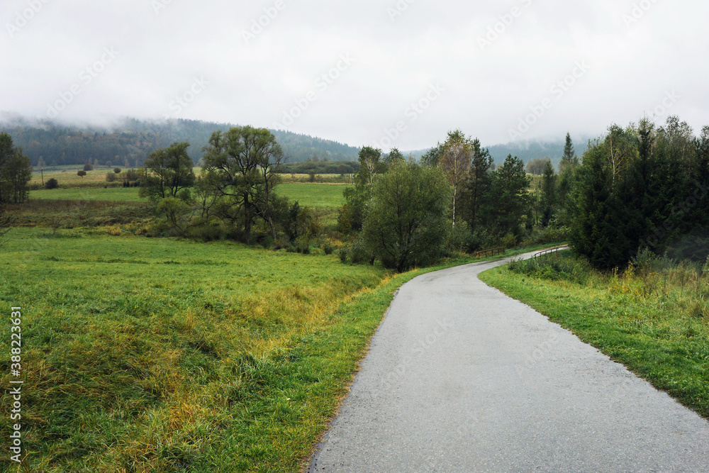 Rainy foggy weather. Bieszczady National Park. Curvy asphalt road. Idyllic autumn hills landscape. Travelling through southern Poland. Mountain road serpentines.