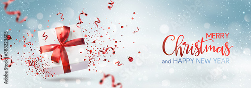 Merry Christmas and Happy New Year text on blue snowy background with gift box, red ribbon, decoration, sparkles, confetti, bokeh. Xmas holiday card. Vector Illustration, realistic vector