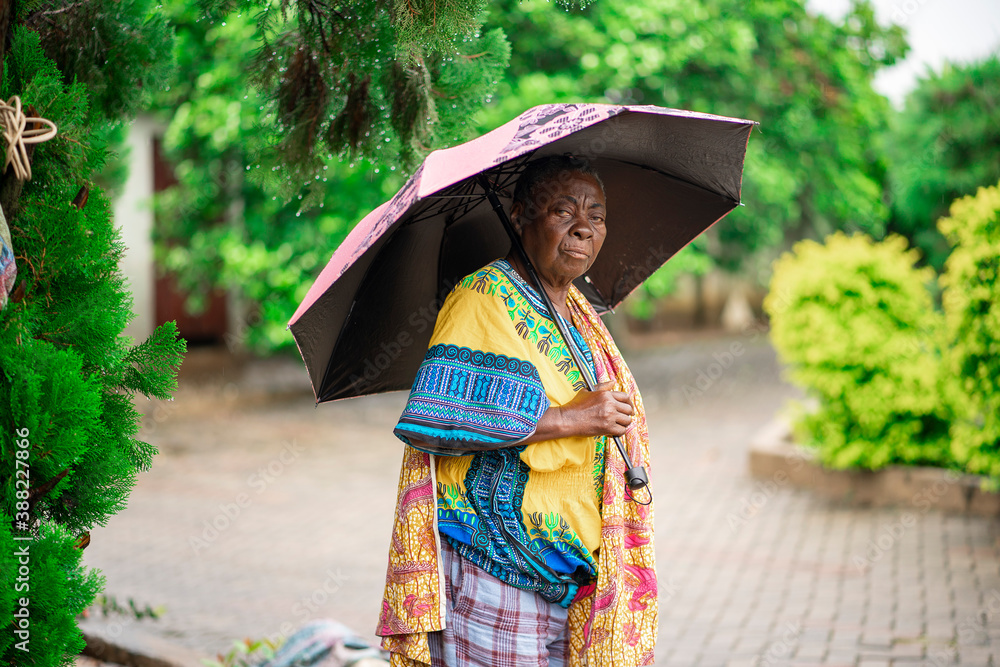 image of old african woman, holding umbrella-out door concept image of old african woman, holding umbrella-out door concept