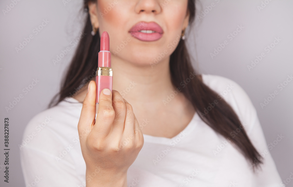 Beautiful young woman, lipstick and gray background. Beautiful young woman, lipstick and gray background.
