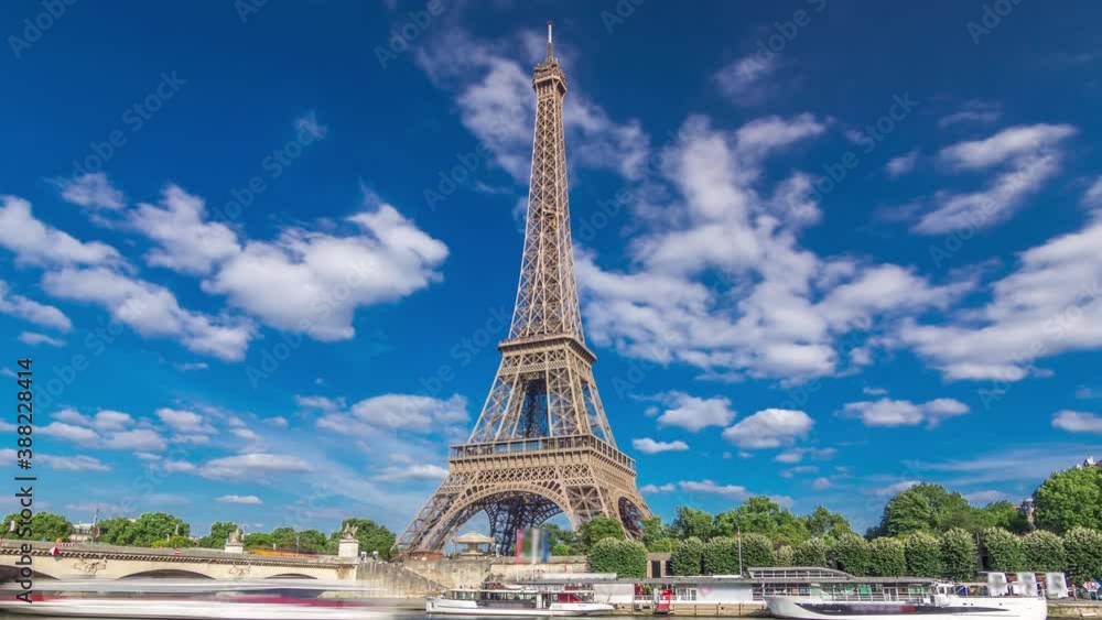 The Eiffel tower timelapse hyperlapse from waterfront at the river Seine in Paris. Ship and boats on river at sunny summer day