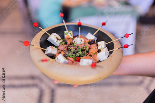 Skewer plate of fresh cheese, salmon and spices tapas in a wooden bowl. Ideal tapas for corporate events, weddings, baptisms, communions. photo