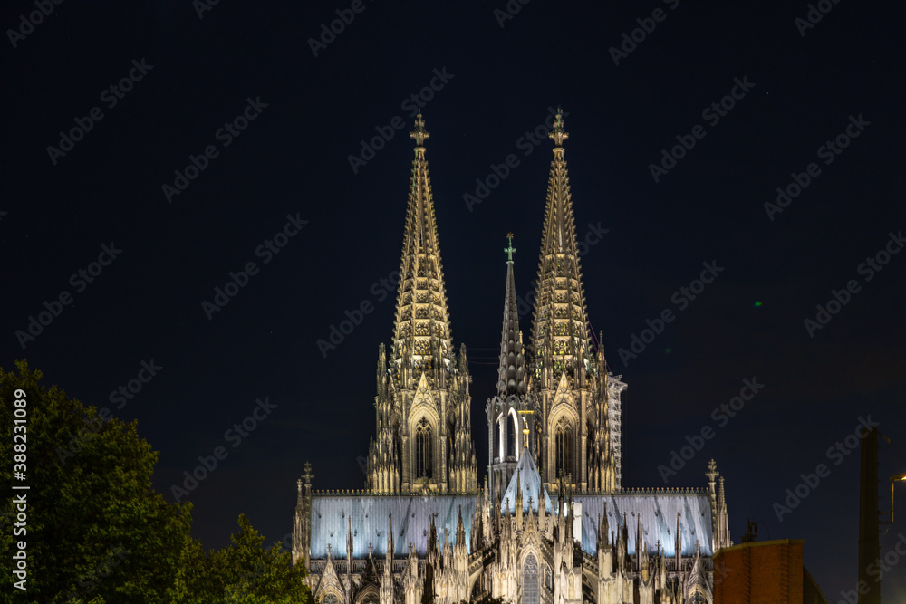 Germany, Cologne, a clock tower lit up at night