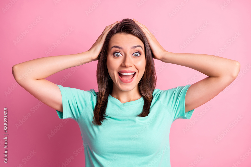 Photo portrait of happy amazed girl keeping head with both hands staring with opened mouth isolated on pastel pink color background Photo portrait of happy amazed girl keeping head with both hands staring with opened mouth isolated on pastel pink color background