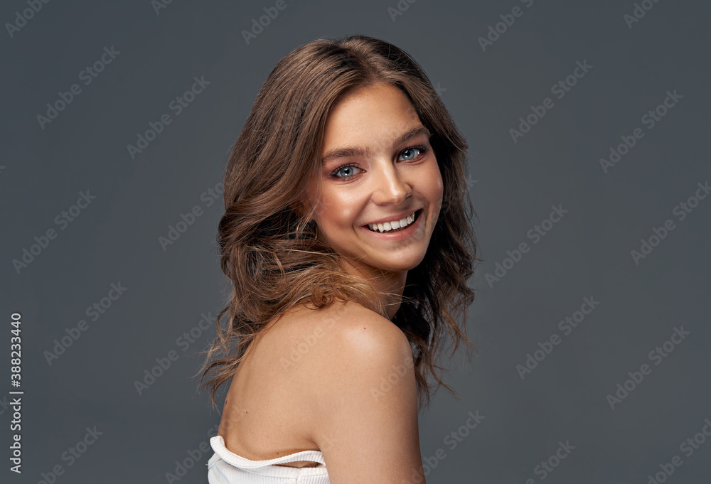 Fototapeta premium Cheerful young woman isolated on gray background