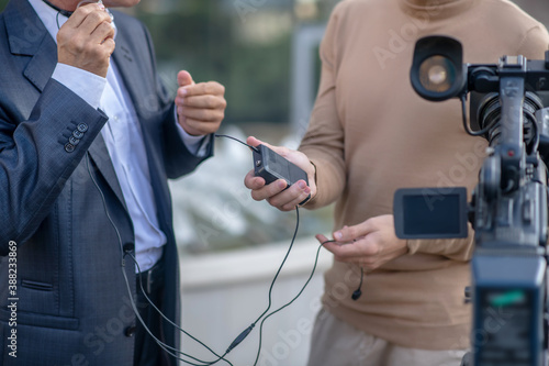 Fotografie Close-up of two pairs of male hands holding headset in front of camera