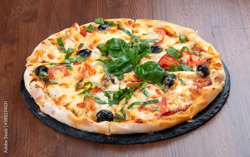 Pizza with salami and basturma, onions and basil