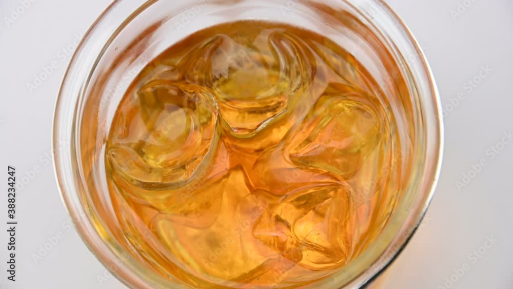 Top view of whiskey glass with ice cubes spinning Top view of whiskey glass with ice cubes spinning
