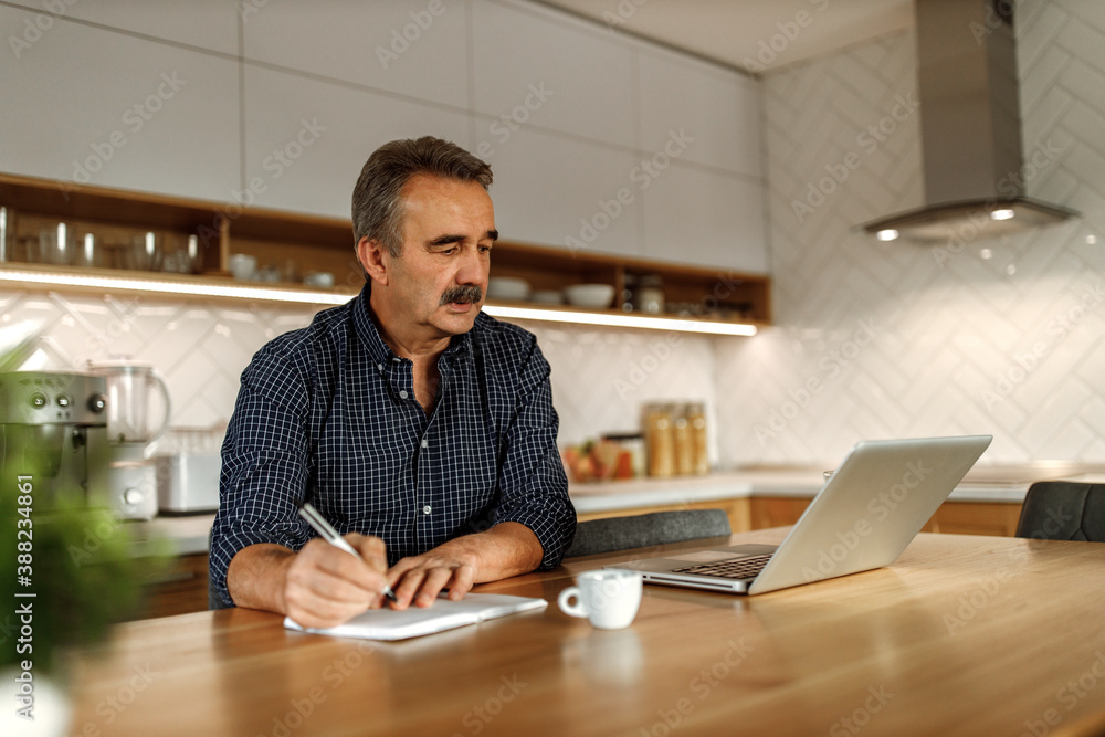 Middle-aged man making notes, writing about his ideas. Middle-aged man making notes, writing about his ideas.
