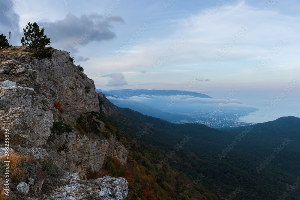 Fantastic view of Yalta from AI-Petri mountain. Autumn mountain landscape. Soft blue clouds hung over the city. Travel to Crimea. A popular tourist destination. Cloudy evening landscape.