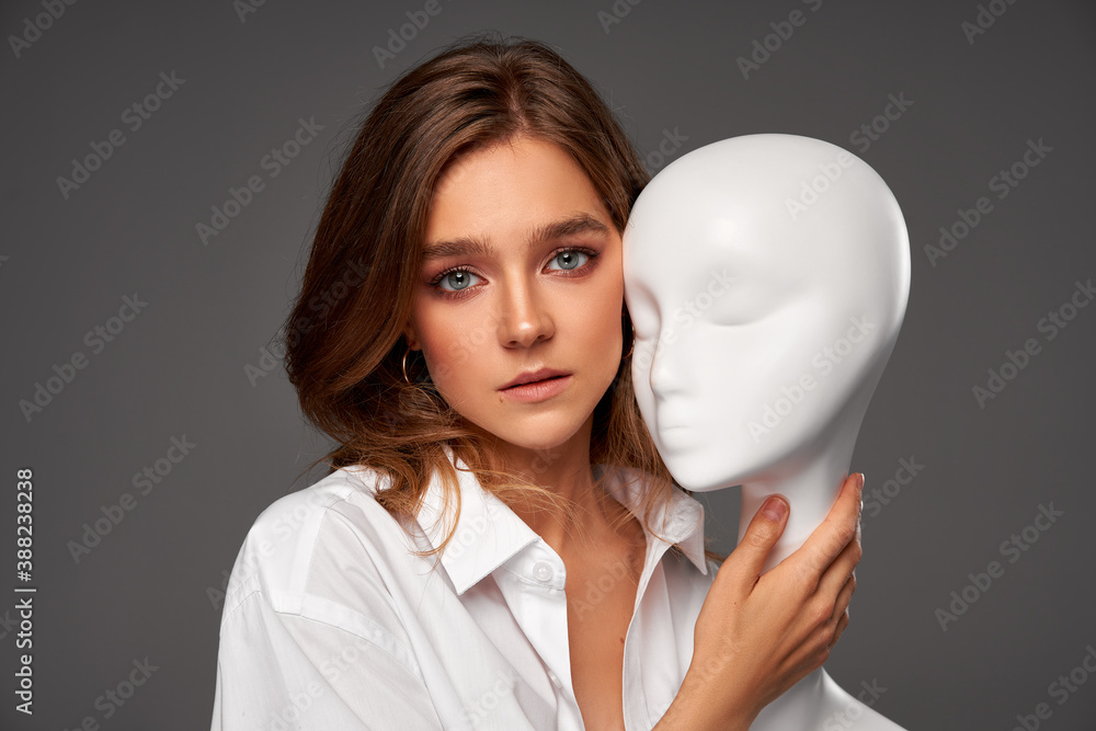 Portrait of young woman with mannequin face isolated on gray background Portrait of young woman with mannequin face isolated on gray background