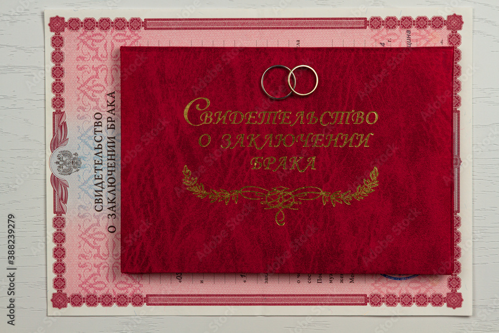 two gold wedding rings and a marriage certificate lie on the table inscription marriage certificate