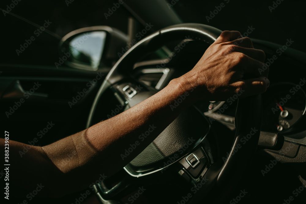 Woman hand holding car steering wheel while she drives.