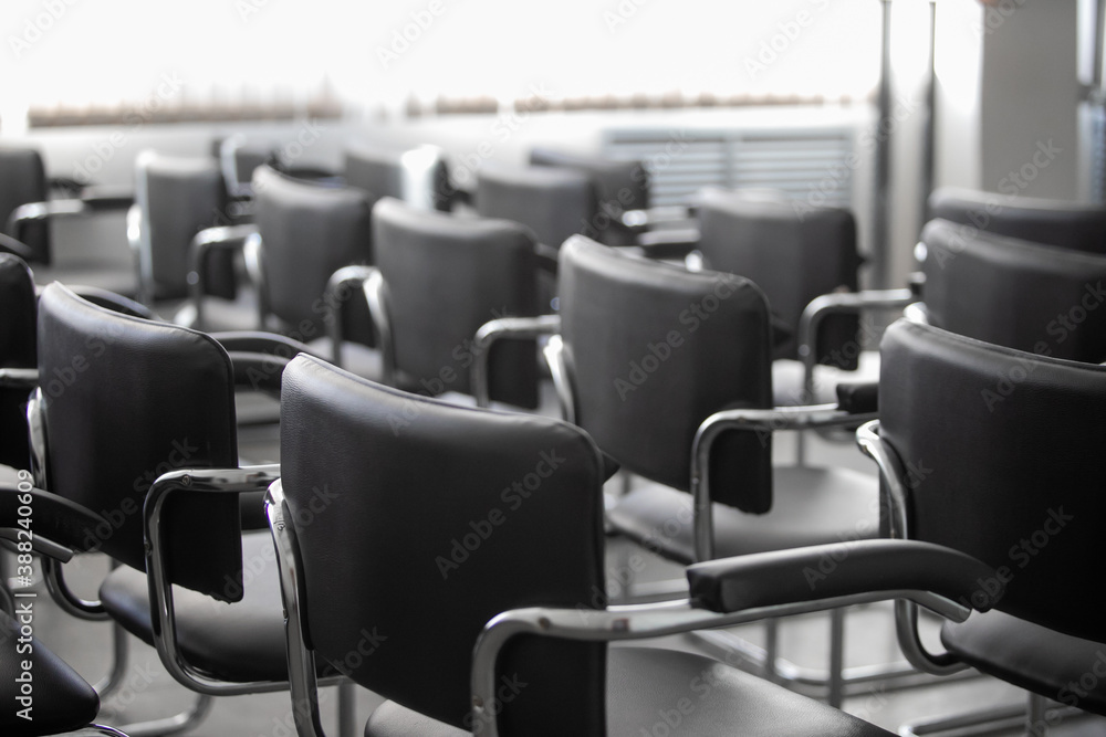 Fototapeta premium Empty black chairs stand in conference hall