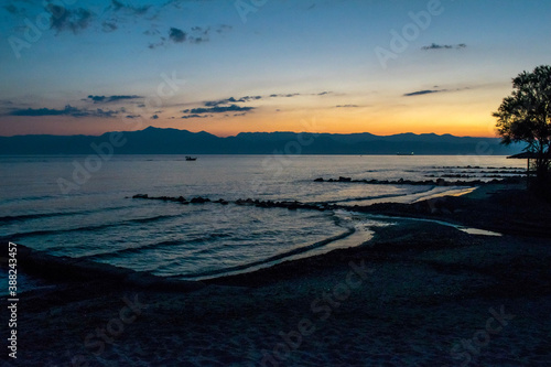 Sunrise over the silhouette of Albanian mountains as seen from Astrakeri, Corfu, Greece photo