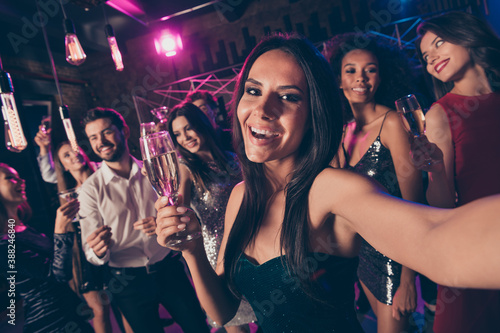 Self photo portrait of happy woman holding champagne glass at prom party