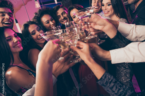 Close-up photo portrait of people drinking champagne cocktails clinking glasses at party