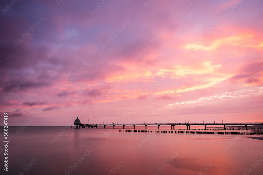Cloudy and colorful sunrise at the beach at baltic sea with pier, Zingst, , Western-Pomerania, Germany