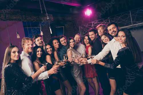 Photo portrait of people clinking champagne glasses together in nightclub