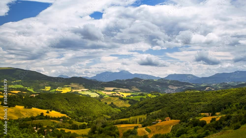 Beautiful sunny day timelapse with moving clouds shadow over rural house, green forest trees, hills, fields and meadows, summer nature outdoor landscape panorama scenery in Italy. Blue sky background Beautiful sunny day timelapse with moving clouds shadow over rural house, green forest trees, hills, fields and meadows, summer nature outdoor landscape panorama scenery in Italy. Blue sky background