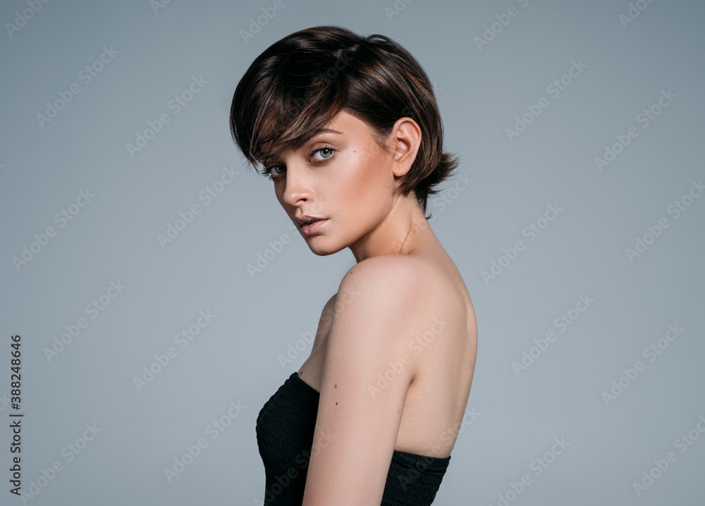 Obraz premium Portrait of a young beautiful brunette girl with stylish short hair