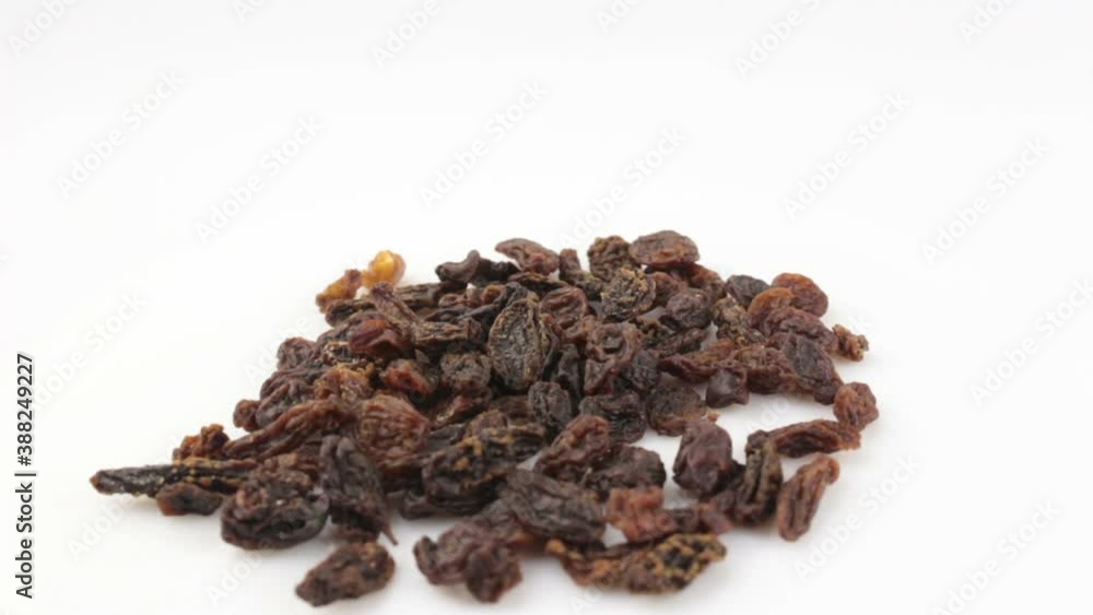 Close-up a handful of sweet raisins rotate on a white background.Sweet organic raisins rotate on a plate. Raisins rotate on a white background. Close-up a handful of sweet raisins rotate on a white background.Sweet organic raisins rotate on a plate. Raisins rotate on a white background.