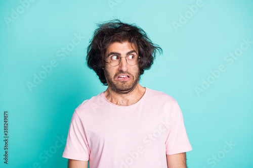 Portrait of speechless crazy guy looking empty space wear spectacles pastel pink t-shirt isolated on teal color background