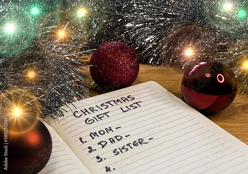 Colorful Christmas lights and a handwritten gift list. An English inscription in the notebook 