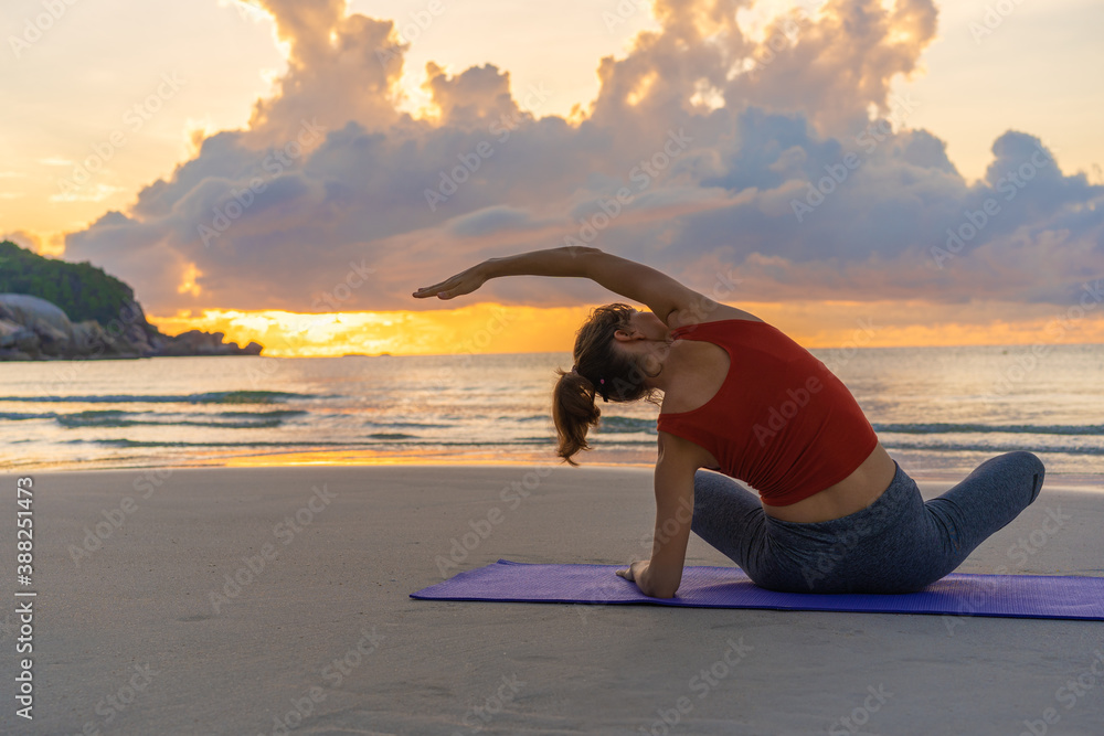 Woman practicing yoga on the beach