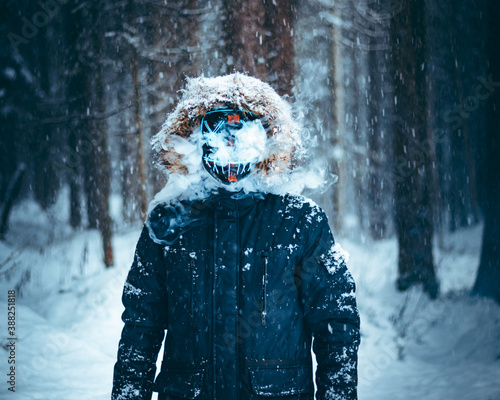 A man in a black jacket wearing a blue purge mask photo