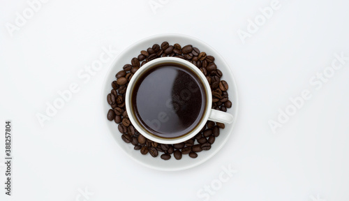 White Cup and saucer with coffee and coffee beans. Top view, white background. Free space for text. © Александра Туркина