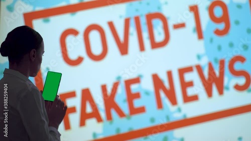 A beautiful girl in front of the display watches the news, gets the latest information about the epidemic when she finishes the pandemic and lockdown, covid 19 fake news