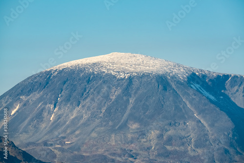 Snow covered mountain peak with clear blue skies.