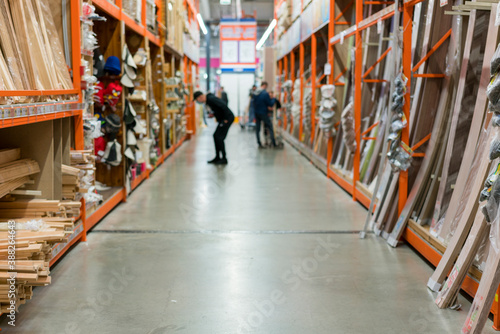 man in a protective medical mask in a hardware store chooses boards. man is protected from the coronovirus. selected focus