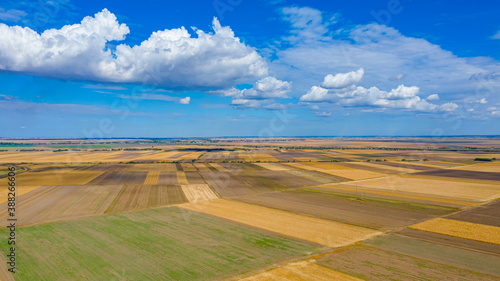 Aerial view of agricultural fields with shadows from white clouds