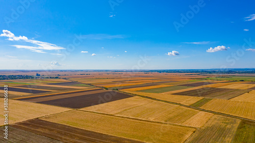 Aerial view of agricultural fields and blue sky with white clouds