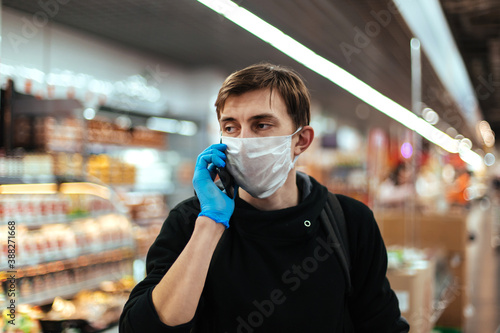 close up. young man in a protective mask talking on his smartphone.