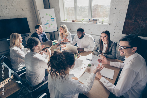 Photo of success business people eight diversity age race colleagues sit table share anti crisis crash ideas team professionals 2020 budget improvement speaking discussion office indoors photo