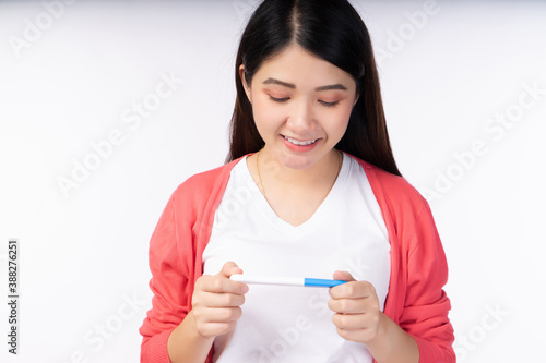 Woman new mom holding pregnancy test on white background.