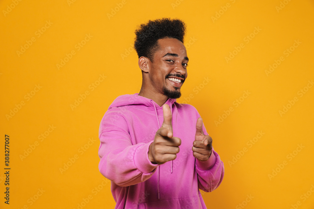Happy african american guy pointing fingers at camera and smiling Happy african american guy pointing fingers at camera and smiling
