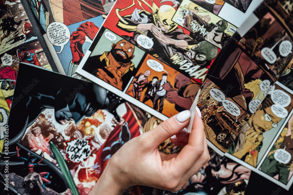Naklejka premium hand flipping through comic book pages. Comics background. Rostov-on-Don, Russia. 1 August 2019