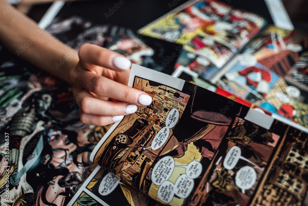 Naklejka premium hand flipping through comic book pages. Comics background. Rostov-on-Don, Russia. 1 August 2019