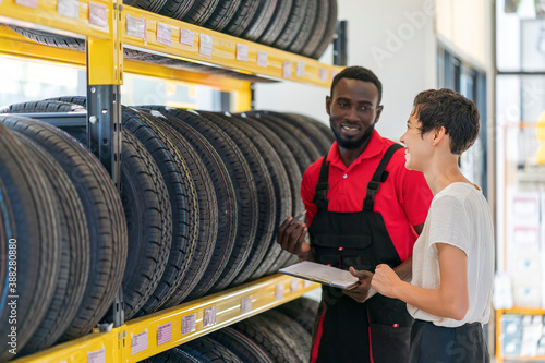 A technician provide service and talking to a customer in the auto service canter/tires service center