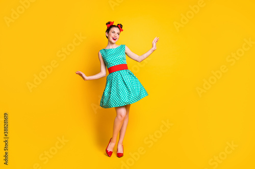 Full length body size view of nice charming cheerful girl wearing teal dress dancing posing isolated over bright yellow color background