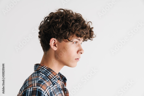 Handsome curly guy with earring posing and looking aside