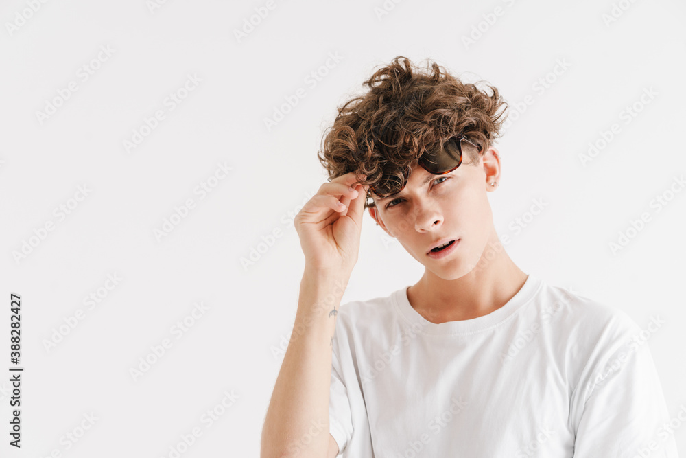 Young curly guy in sunglasses looking at camera Young curly guy in sunglasses looking at camera